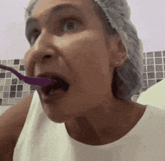 a woman with a purple toothbrush in her mouth