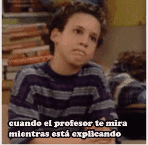 a boy in a striped shirt is sitting at a desk with a caption in spanish