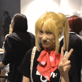 a woman giving a peace sign wearing a black shirt that says u on it