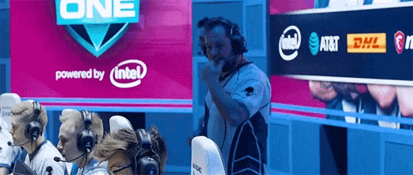 a man wearing headphones stands in front of a sign that says one powered by intel