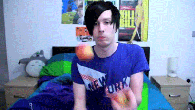 a man wearing a blue shirt that says new york is holding an apple