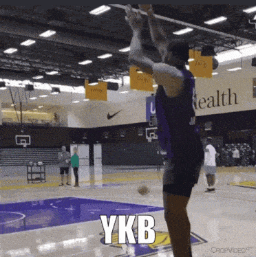 a basketball player in a purple jersey is jumping up in the air with the word ykb above him