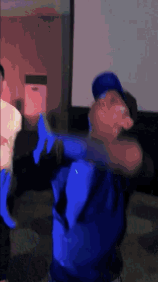 a blurry picture of a man wearing a blue shirt and a blue hat