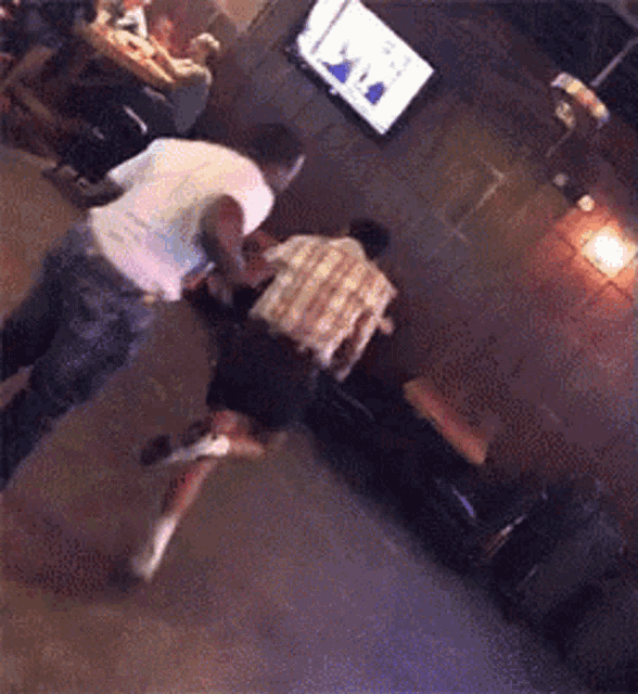 a blurry picture of two men fighting in a room