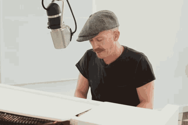a man in a hat is playing a white piano