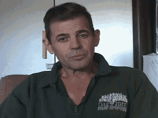 a man wearing a green shirt that says oaktree