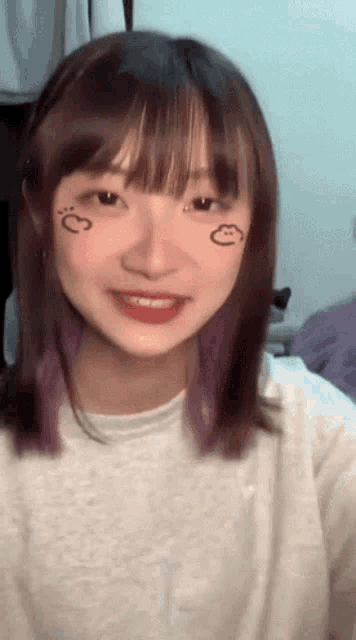 a girl with purple hair has a smiley face drawn on her face