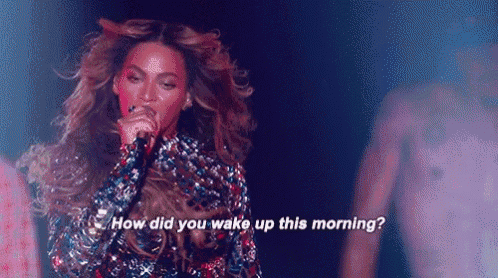 a woman is singing into a microphone on a stage and says `` how did you wake up this morning ? ''