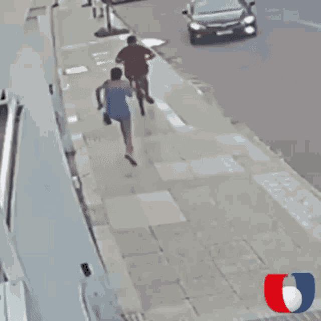 a black car is parked on a sidewalk with a red white and blue logo