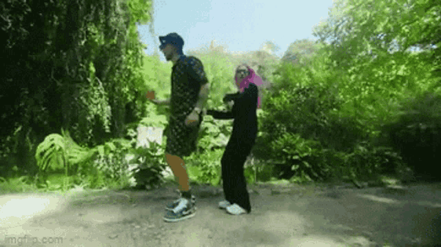 a man and a woman are dancing together in a park .