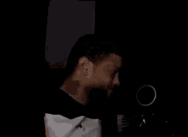 a man is drinking from a bottle of alcohol in a dark room .