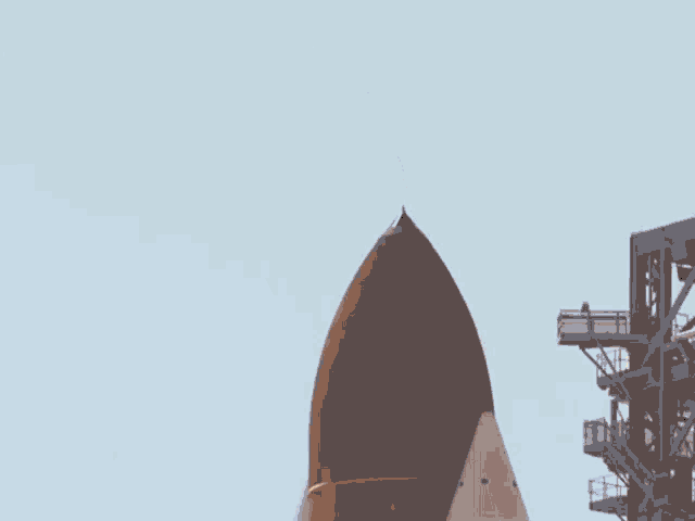 a space shuttle is flying through the air with a blue sky in the background .