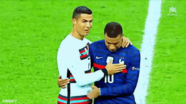 two soccer players are hugging each other on a field .