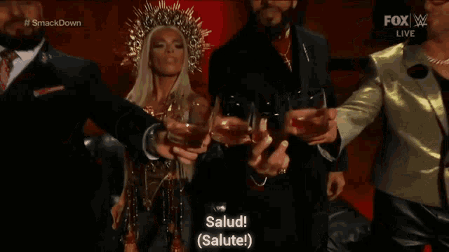 a group of people are standing next to each other holding glasses of liquor .