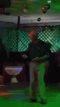a man in a blue shirt is standing in front of a green screen