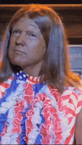 a man with long hair is wearing a red white and blue dress