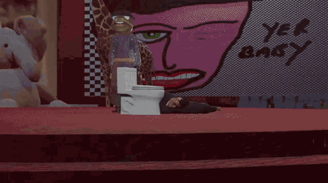 a man laying on the floor next to a toilet in front of a pink wall
