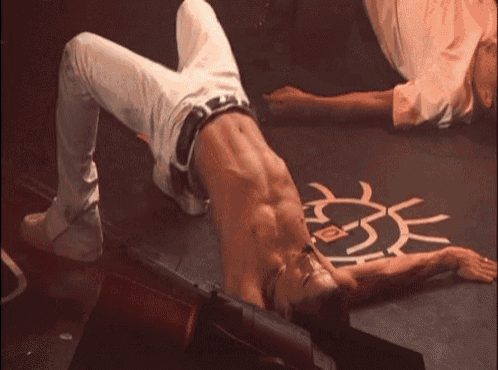 a man is doing a handstand on a stage with his shirt off .