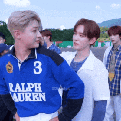 a man wearing a blue ralph lauren polo shirt stands next to another man