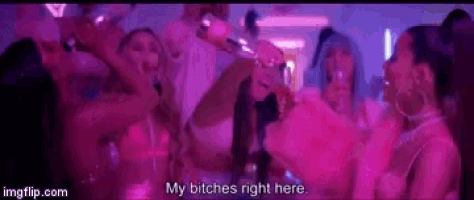 a group of women are having a party in a pink room and one of them is holding a bottle of wine .
