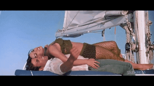 a man and a woman laying on a boat with sneha written on the bottom