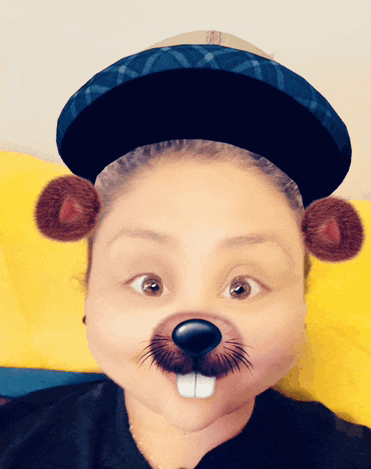 a woman wearing a hat with a beaver face painted on it