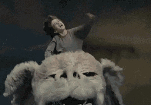 a man is riding on the back of a stuffed animal with his fist in the air .