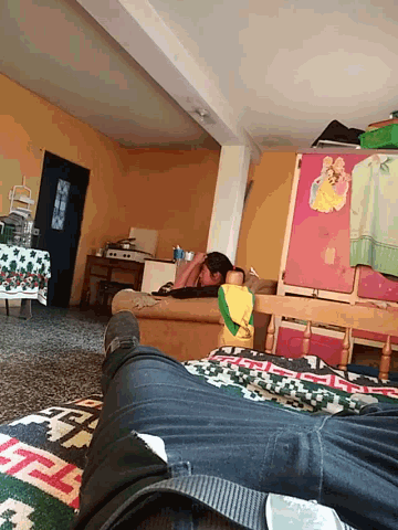 a person 's feet are visible in a room with a table and chairs and a rug
