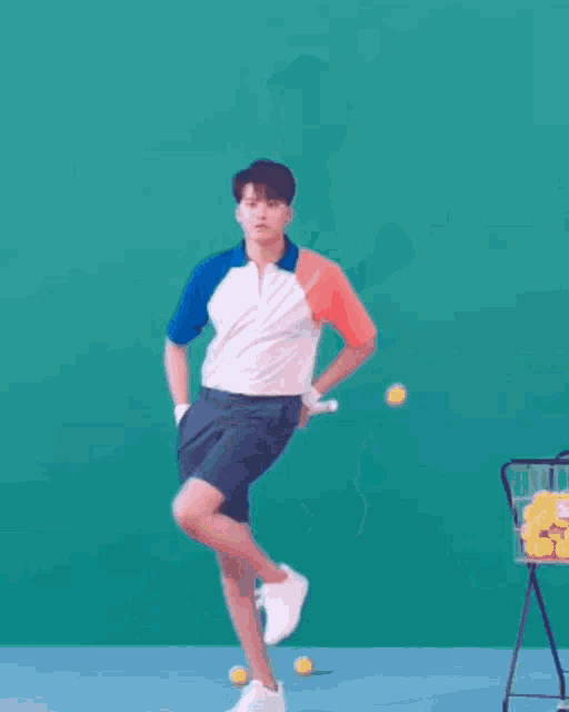 a man is playing tennis on a court with balls in the background