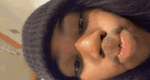 a close up of a person 's face with a hat on .