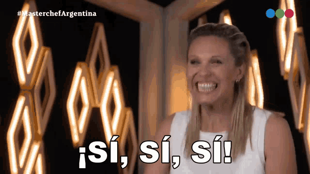 a woman is smiling in front of a sign that says " si si si "