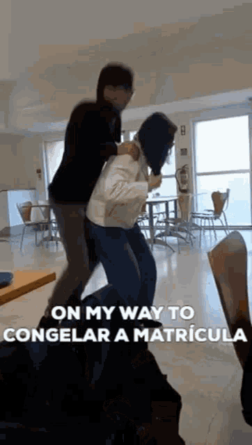 a man is carrying a woman on his back in a room with tables and chairs .
