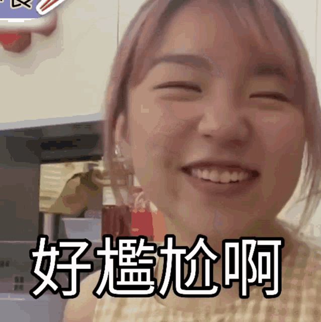 a woman with pink hair is smiling with chinese writing behind her
