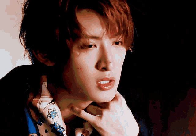 a close up of a young man 's face with a hand on his chin
