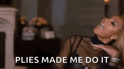 a woman is laughing and saying `` plies made me do it '' while sitting in a living room .
