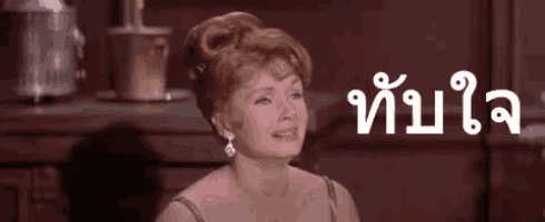 a woman in a dress is sitting in front of a table with buckets on it and a sign in a foreign language .