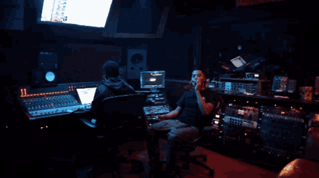 a man sits in a recording studio talking on his phone