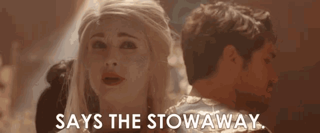 a man and a woman are standing next to each other and the woman is saying `` says the stowaway '' .