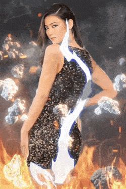 a woman in a black dress stands in front of fire