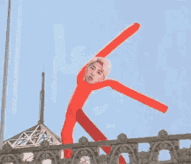 a man in a red suit is standing on a balcony .