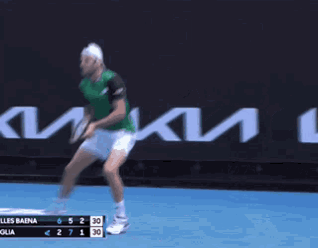 a man in a green shirt is swinging a tennis racquet