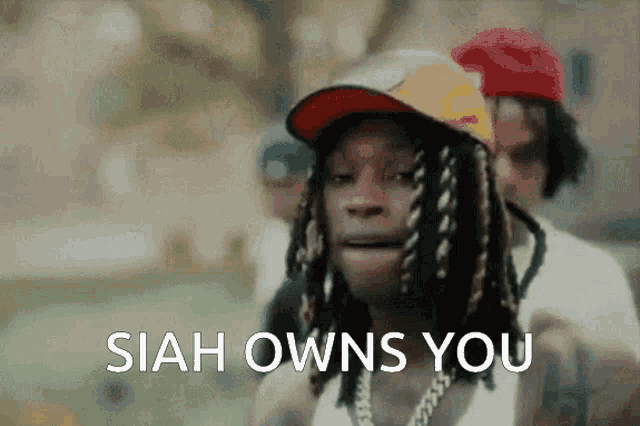 a man with dreadlocks is wearing a hat and says " siah owns you " .