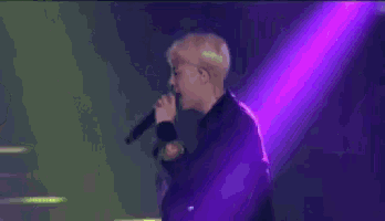 a purple and green light beam is shining on a stage .