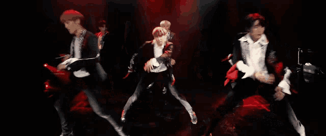 a group of men are dancing on a stage