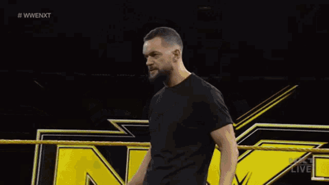 two men are wrestling in a ring and one of them is pointing at the other .