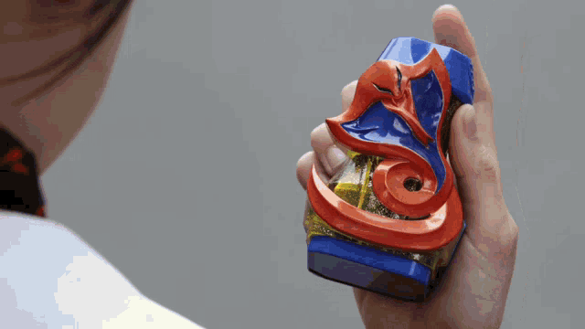 a person is holding a blue and orange object that looks like a snake