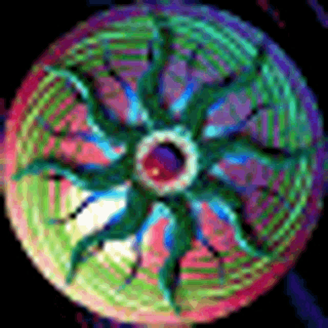 a rainbow colored circle with a green center and a purple center on a black background .