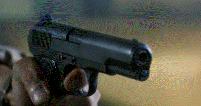 a person is holding a small black gun in their hand .