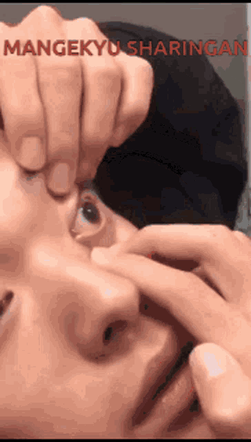 a close up of a person 's eye with the words mangekyu sharingan on the bottom right
