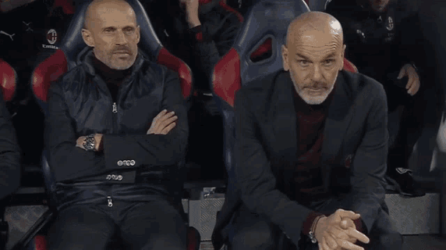 two men sitting in a stadium with the word futbol karim written on the bottom